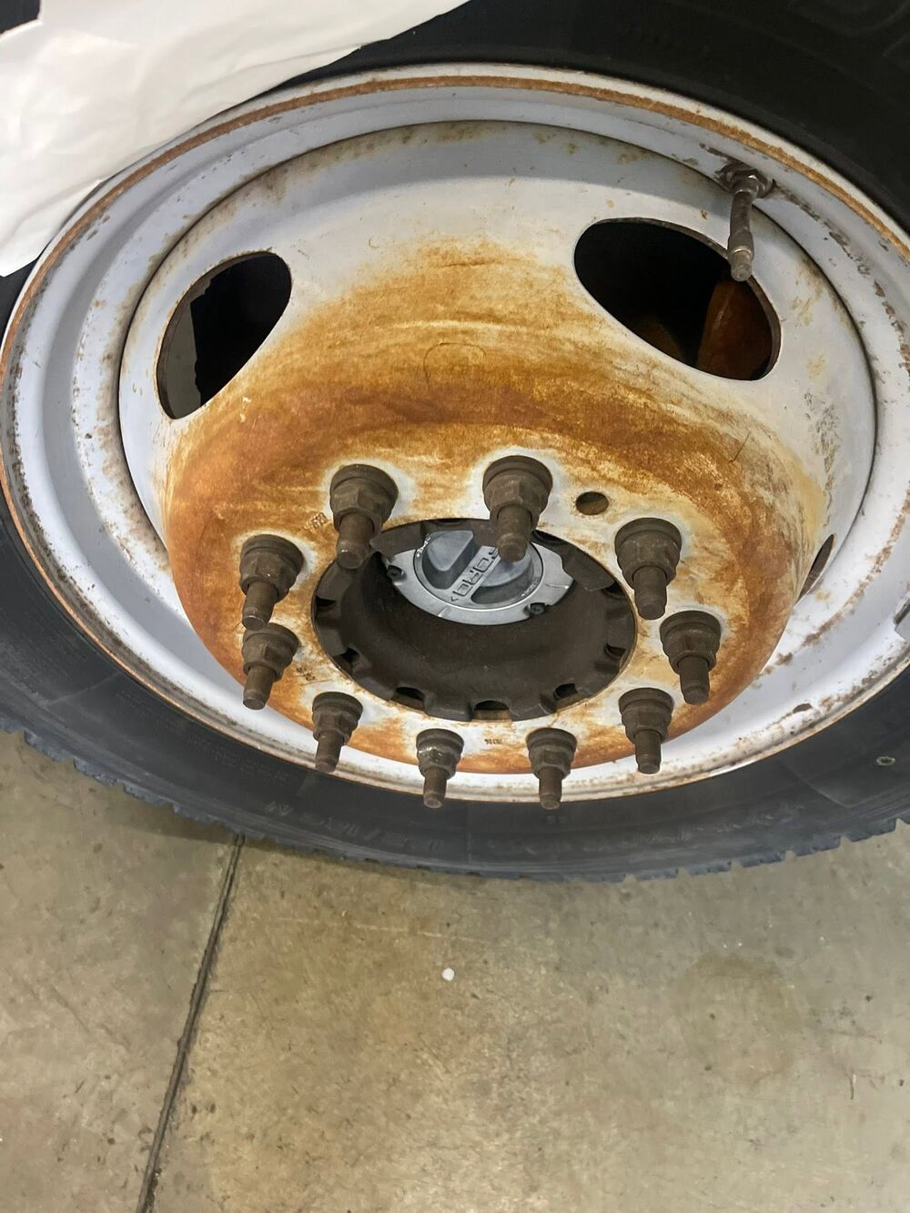 Truck wheel stained orange with rust and brake dust before cleaning